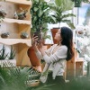 asian woman looking at plants in a local plant shop